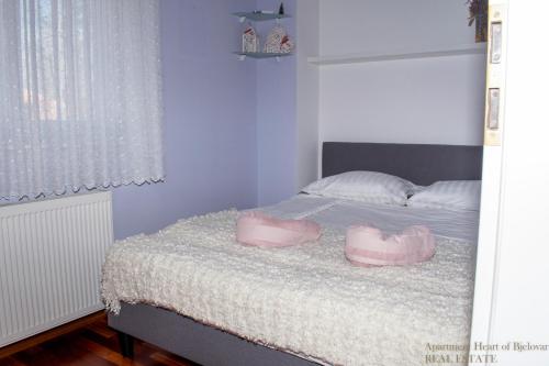 een slaapkamer met een bed met twee roze schoenen erop bij Apartment Heart of Bjelovar in Bjelovar