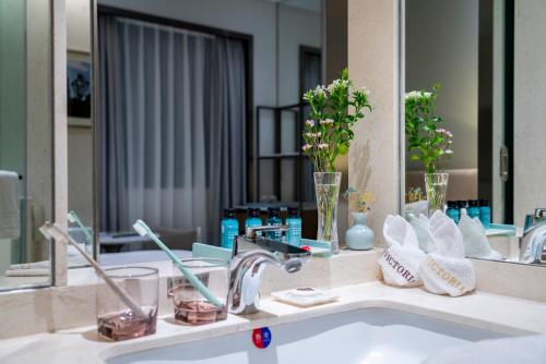 een badkamerbar met een wastafel en een spiegel bij Guangzhou Victoria Hotel in Guangzhou