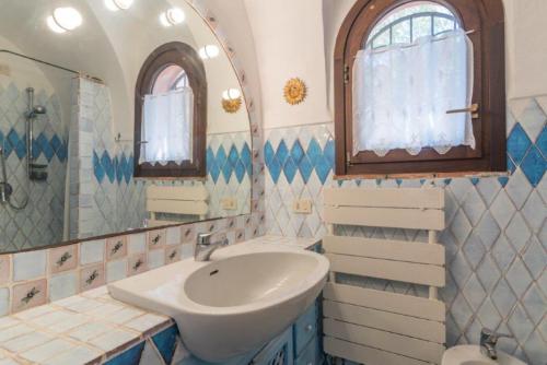 uma casa de banho com um lavatório e um espelho em Villa Baia - Porto Rafael em Palau