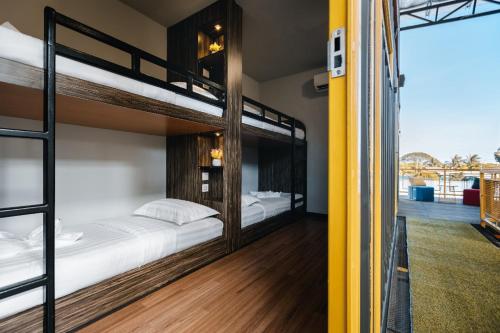 a bedroom with two bunk beds and a balcony at 7 Inn Semporna in Semporna