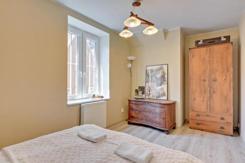 a bedroom with a bed and a dresser and a window at Hello Apartments Double Loft in Gdańsk