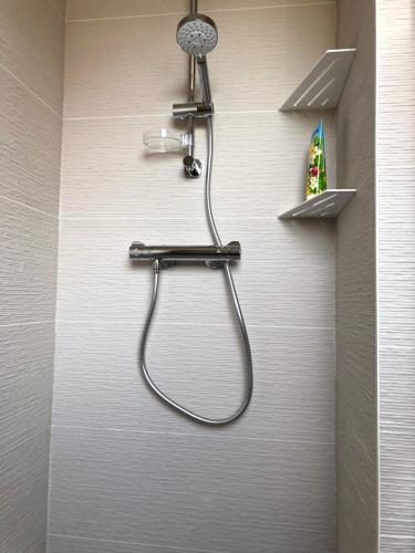 una ducha en la pared de un baño en Face à la mer, bel appartement, en Saint-Nazaire