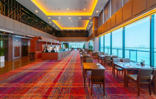 - une salle à manger avec des tables, des chaises et des fenêtres dans l'établissement Hotel JCS Yeosu, à Yeosu