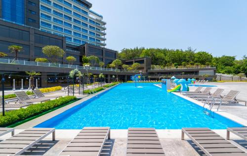 a large swimming pool with a person jumping into it at Hotel JCS Yeosu in Yeosu