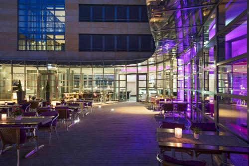 a restaurant with tables and chairs in a building at FOUR Munich Neue Messe in Munich