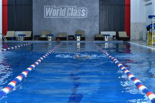 a person is swimming in a swimming pool at Dora Hotel in Shymkent