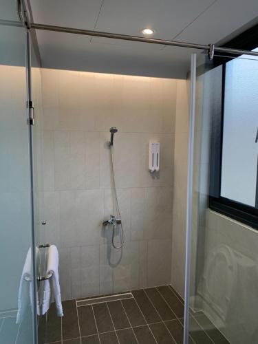 a shower with a glass door in a bathroom at Planet 23 in Chiayi City