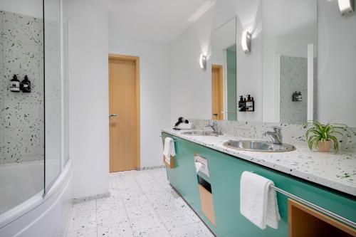 W łazience znajduje się umywalka i lustro. w obiekcie INNSiDE by Meliá München Neue Messe w Monachium