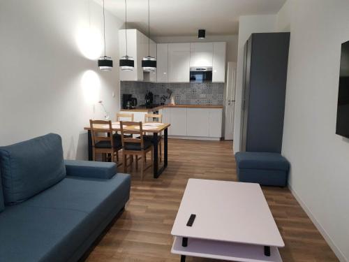 a living room with a couch and a table and a kitchen at Apartament Zimowiec in Duszniki Zdrój