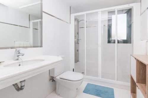 a white bathroom with a toilet and a shower at 2207-Modern apt with terrace and amazing seaview in Casares