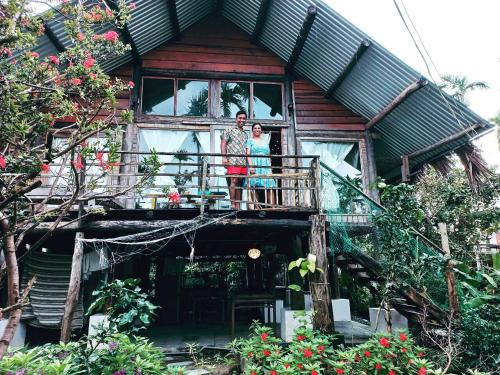 a man and woman standing on the balcony of a house at Hoi An Mercy homestay in Hiếu Nhơn