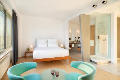 1 dormitorio con 1 cama y 1 silla azul en INNSiDE by Meliá München Neue Messe, en Múnich