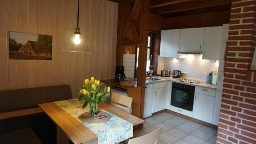 eine Küche mit einem Tisch und einer Blumenvase darauf in der Unterkunft Ferienhaus Becker in Bispingen