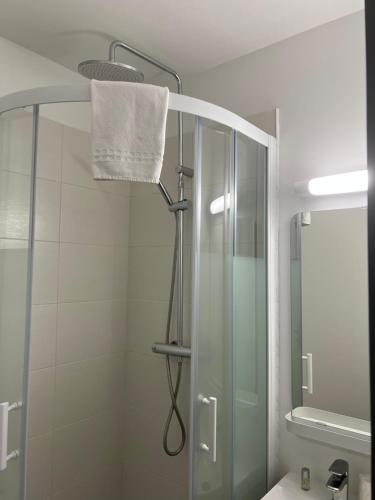 a bathroom with a shower with a glass shower stall at HOTEL DE LA PAIX Lyon Sud Givors in Givors