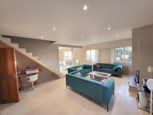 - un salon avec un canapé bleu et un escalier dans l'établissement Villa lours, au Trayas