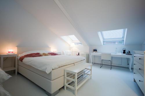 a white bedroom with a bed and a sink at B&B De Kloostertuin in Middelburg