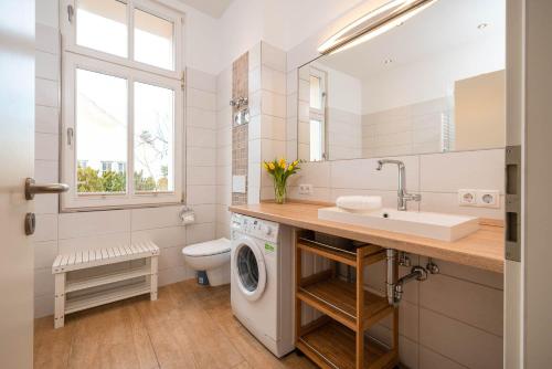 a bathroom with a sink and a washing machine at Villa Anna -Whg 09 in Ahlbeck