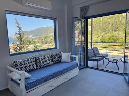 a living room with a couch and a large window at Katerina's Village Agios Nikitas in Agios Nikitas