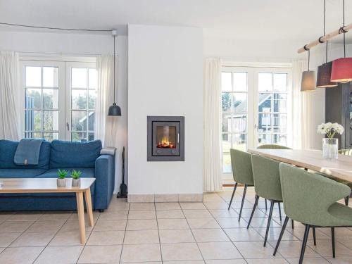 a living room with a blue couch and a fireplace at 8 person holiday home in Gjern in Gjern