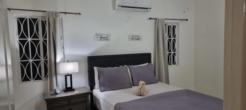 オーチョ・リオスにあるKomfort Getaway Villaのベッドルーム(ベッド1台、動物の詰め物付)