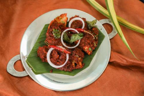a plate of food with meat and onions on a table at Enrise by Sayaji, Khed Shivapur Pune in Pune