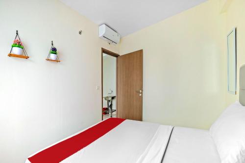 een slaapkamer met een wit bed en een rode deken bij Skyland Podomoro Golf View Apartemen in Bogor
