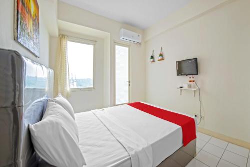 a bedroom with a bed and a tv in it at Skyland Podomoro Golf View Apartemen in Bogor