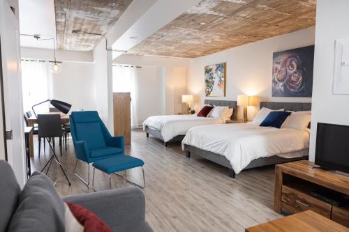 a hotel room with two beds and a tv at Le Central in Rouyn
