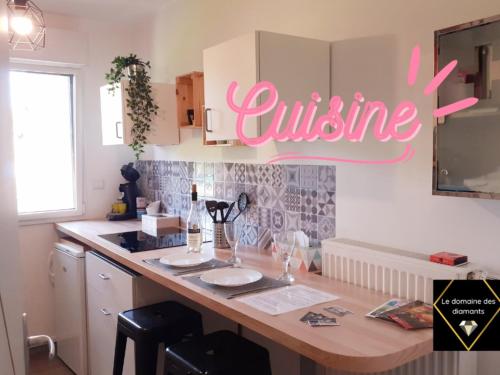 a kitchen with a counter with a sign that reads cuisine at Fraisier, hotel artres - valenciennes in Quérénaing