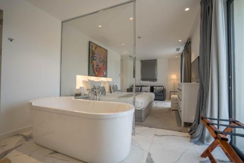 ein großes Badezimmer mit Badewanne und ein Schlafzimmer in der Unterkunft Hotel le Mandala in Saint-Tropez