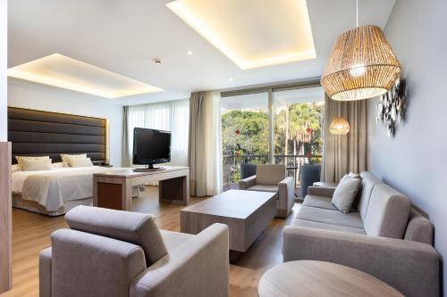 a hotel room with a bed and a living room at Hotel Colon Rambla in Santa Cruz de Tenerife