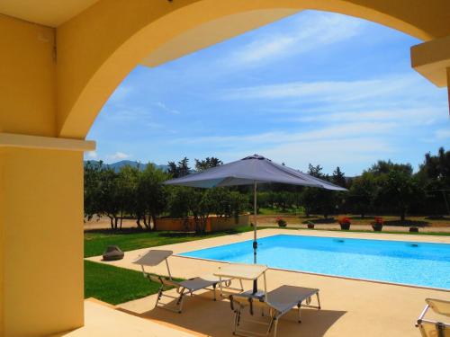 um pátio com uma mesa e um guarda-sol ao lado de uma piscina em Villa Bulcrini em Sant' Isidoro