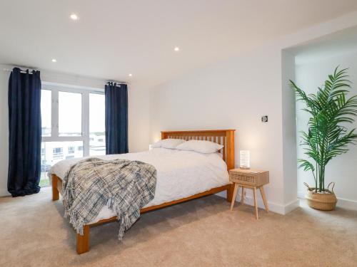 a bedroom with a bed and a potted plant at Fistral Retreat in Newquay