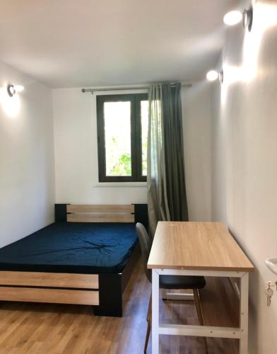 Kleines Zimmer mit einem Bett und einem Tisch in der Unterkunft Apartement 5 rooms 20 mins from the beach in Nizza