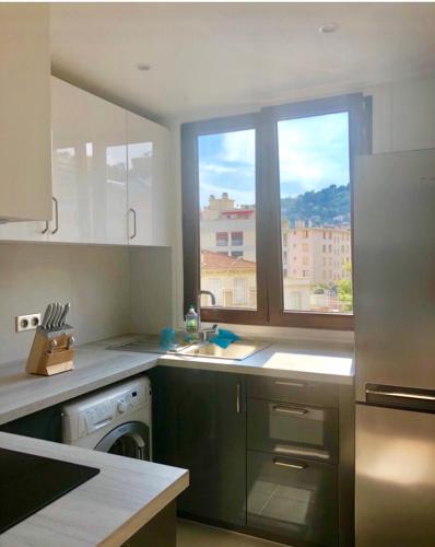eine Küche mit einem Waschbecken und einem Fenster in der Unterkunft Apartement 5 rooms 20 mins from the beach in Nizza