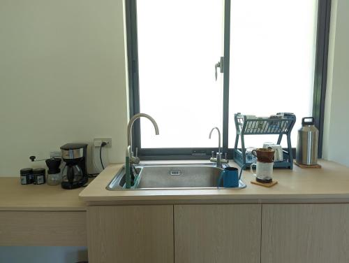 a kitchen counter with a sink and a window at Ran Ran 29 Guest House in Beigan
