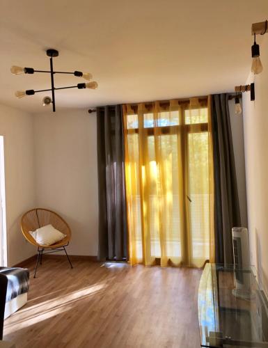 ein Wohnzimmer mit einem Stuhl und einem Fenster in der Unterkunft Apartement 5 rooms 20 mins from the beach in Nizza