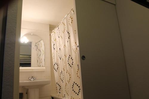 a bathroom with a shower curtain and a sink at Appartement Lac de Payolle in Campan