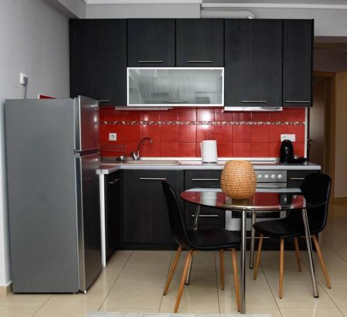 una cucina con armadi neri, tavolo e frigorifero di Stelina’s Cosy Loft - Ideal Spot a Salonicco