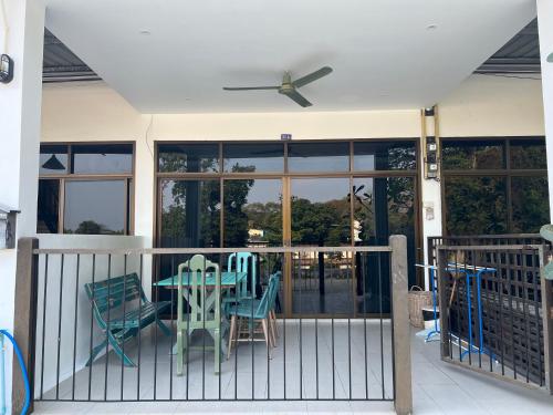 een veranda met een tafel, stoelen en ramen bij Island House Rentals 40 in Ko Samed