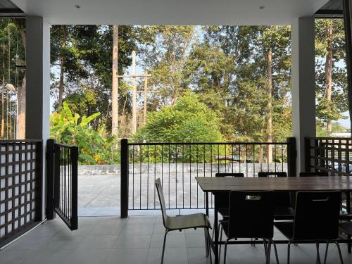 een veranda met een tafel en stoelen en een hek bij Island House Rentals 48 in Ko Samed