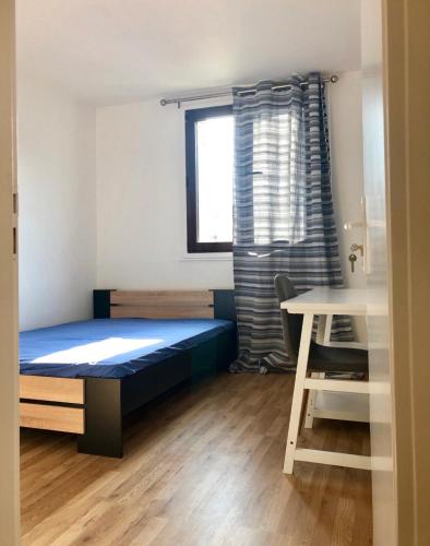 Schlafzimmer mit einem Bett, einem Tisch und einem Fenster in der Unterkunft Apartement 5 rooms 20 mins from the beach in Nizza