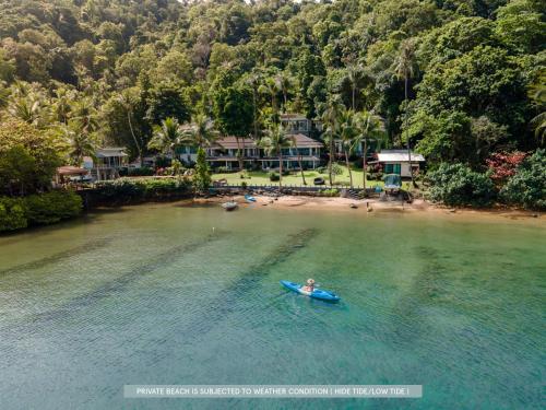 a person in a kayak in the water near a beach at Resolution Resort in Ko Chang