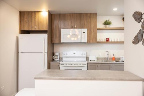 a kitchen with a white refrigerator and wooden cabinets at Le Central in Rouyn