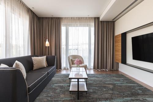 a living room with a couch and a tv at Hyatt Regency Lisbon in Lisbon