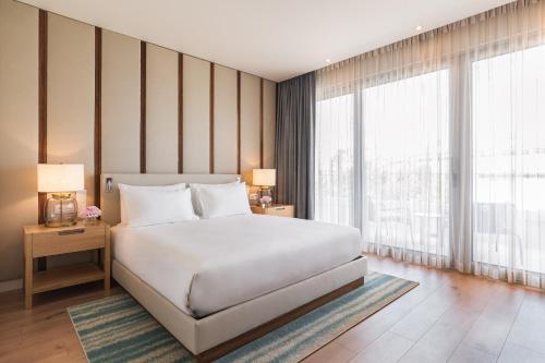 a bedroom with a white bed and a large window at Hyatt Regency Lisbon in Lisbon