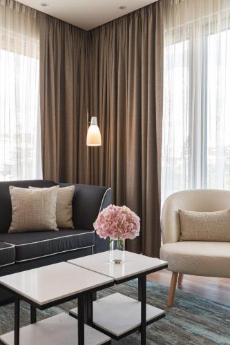 a living room with a couch and a table with flowers at Hyatt Regency Lisbon in Lisbon