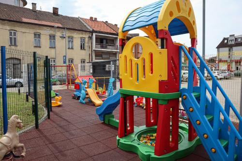 a playground with a slide and a play structure at Drina Hotel in Bijeljina