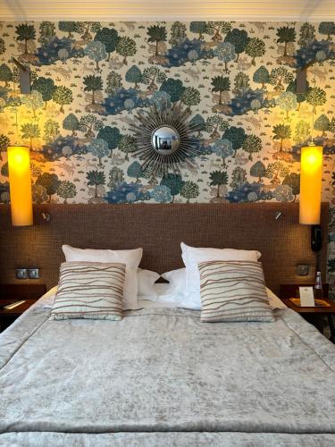 a bedroom with a large bed with two pillows at Hôtel jardin Le Pasteur in Châlons-en-Champagne