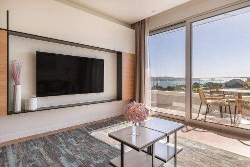 a living room with a large television and a table at Hyatt Regency Lisbon in Lisbon